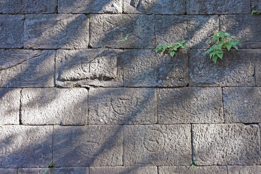藩主の側室たちの住まいがあった数寄屋敷の付近の石垣。石の表面には◯に十文字など、さまざまな形の刻印が刻まれています。