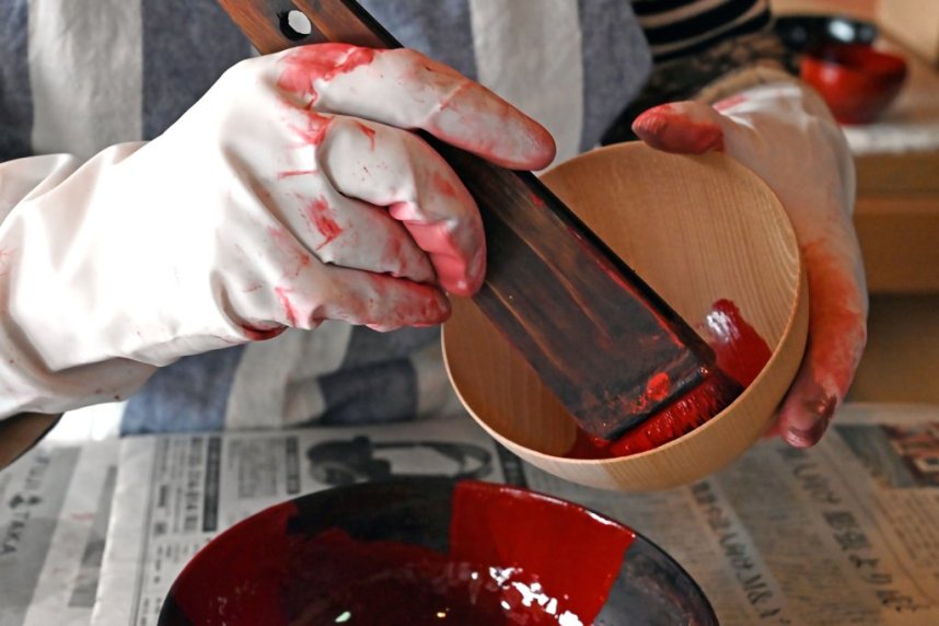 【拭き漆体験】ベースの木地が決まったら、色は伝統的な赤、黒、茶色から１色を選び、ハケを使って全体にムラなく塗る。