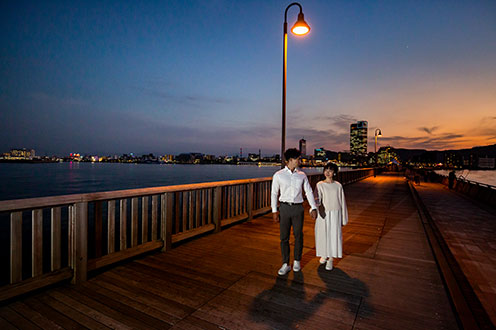 在擁有時尚夜景及紅色玻璃燈塔的港口旁，拍攝一輯夜景婚紗照
